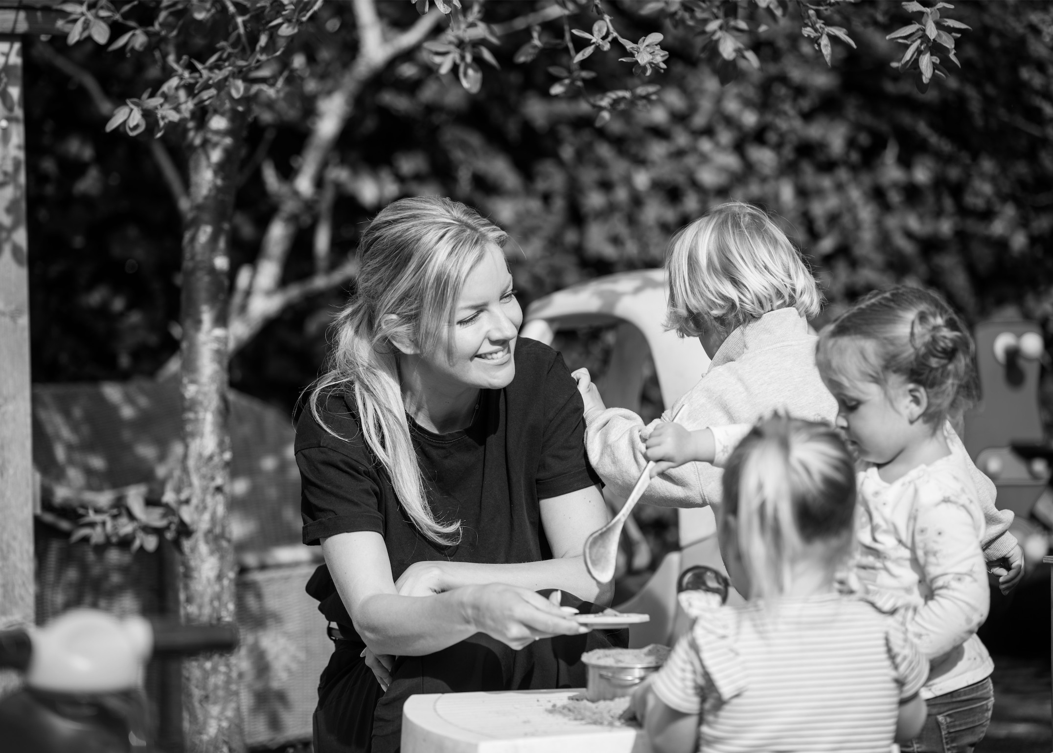Maaike Preuninger spelend met kinderen bij de zandkeuken tijdens een opnamedag